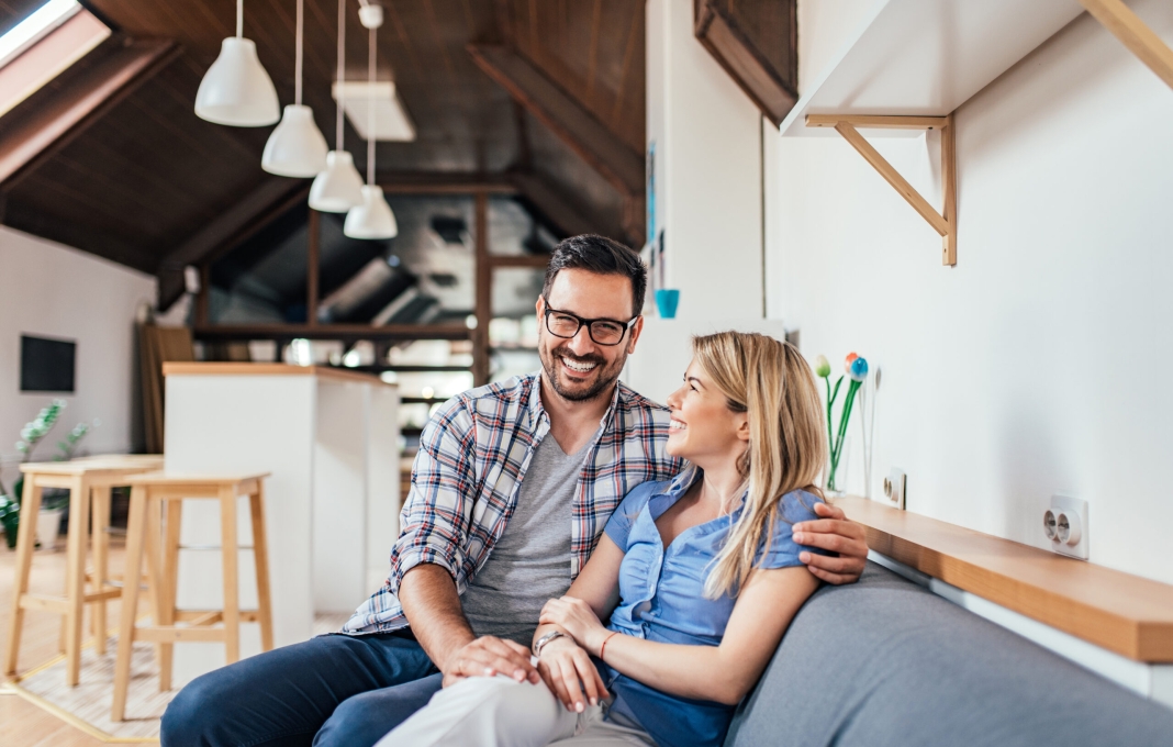 Loving young couple sitting on the sofa at modern apartment.