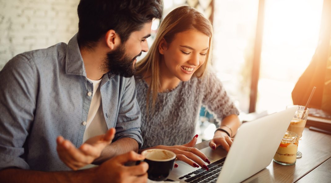 Couple surfing on a laptop at cafe. Couple shopping online or video chatting.