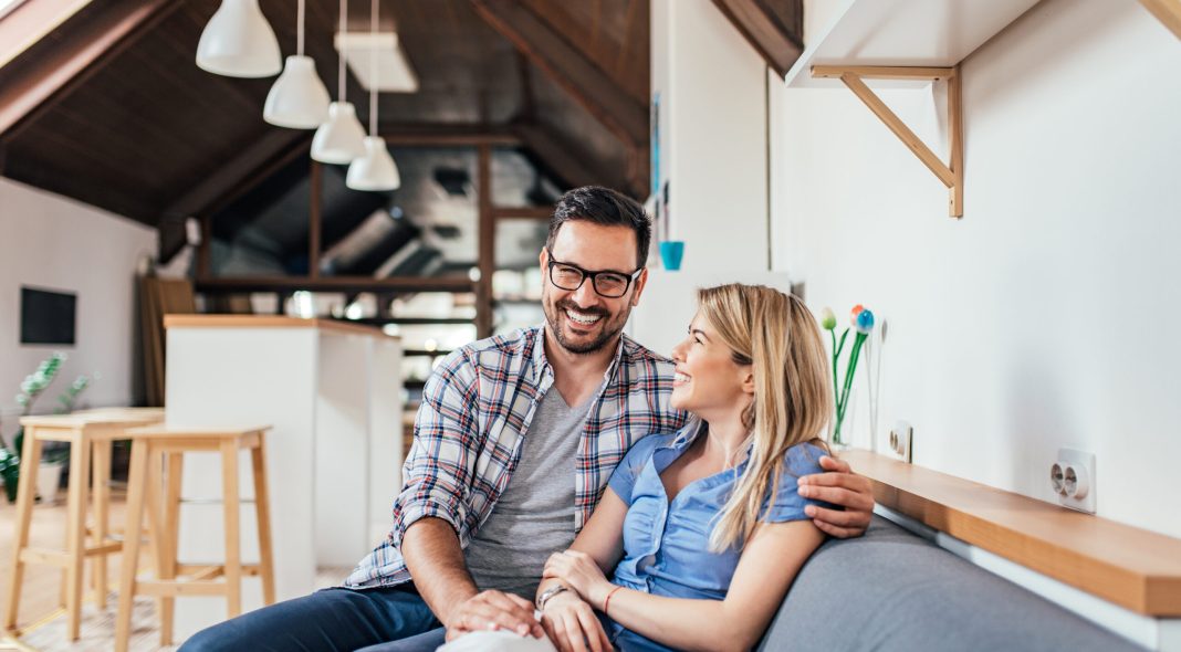 Loving young couple sitting on the sofa at modern apartment.